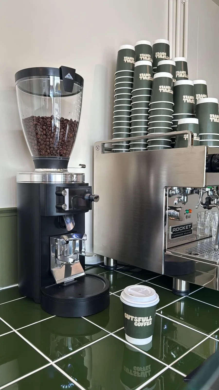 The Rocket espresso machine and grinder on the green tiled counter