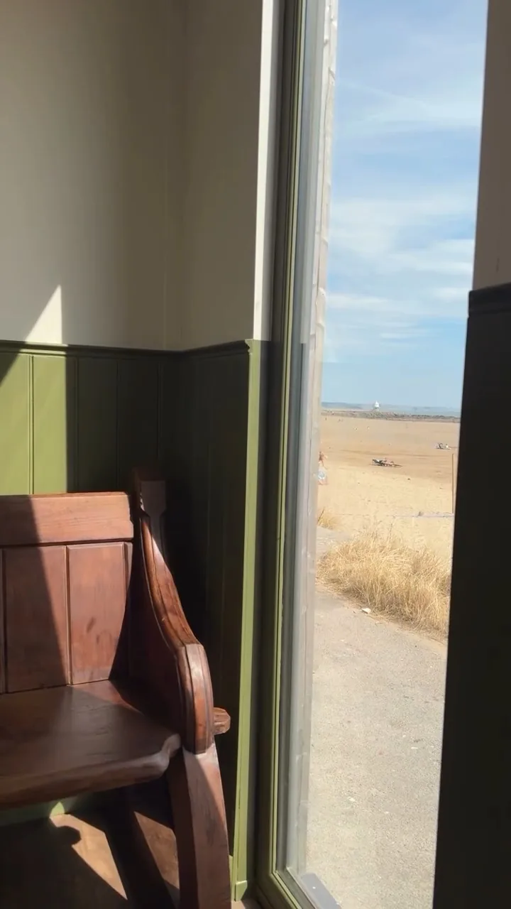 Inside the shop, looking out through the window across the sand