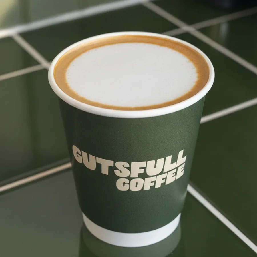 A cappuccino in a Gutsfull takeaway cup