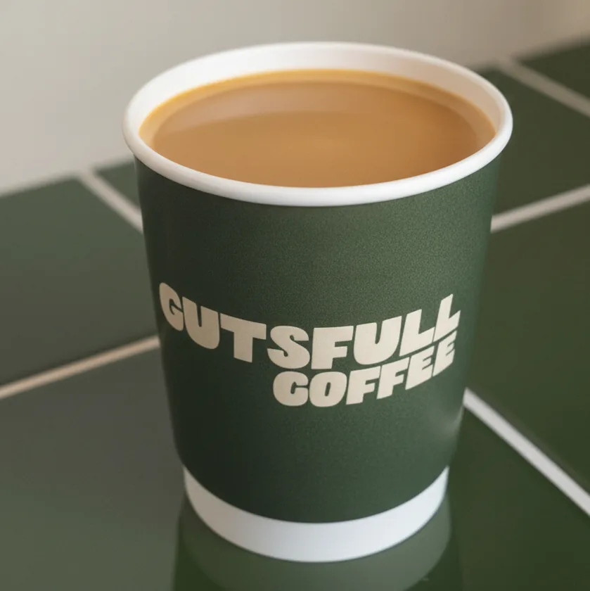 A cortado in a Gutsfull takeaway cup